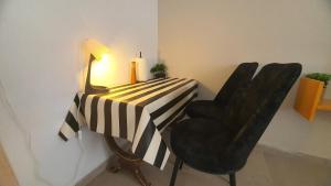 a black and white table with two chairs and a lamp at quiet house in Qiryat Yam