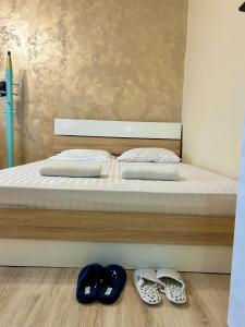 a bed with two pairs of shoes on the floor at ПЕТРОВ 2 in Vratsa