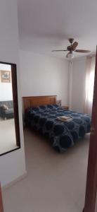 コニル・デ・ラ・フロンテーラにあるGlauka Apartamento tranquilo con Aire Acondicionadoのベッドルーム1室(ベッド1台、天井ファン、鏡付)