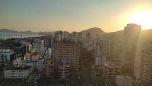 ein Blick auf eine Stadt mit Sonnenuntergang in der Unterkunft Panoramique 180 - Vista Praia in Guarujá