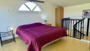 a bedroom with a purple bed and a window at Riells Blau C302 in L'Escala +33 photos