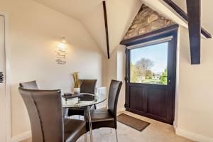 a dining room with a glass table and chairs at Goldfinch cottage in Newton