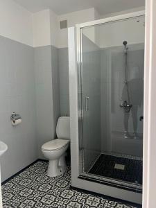 W łazience znajduje się toaleta i przeszklony prysznic. w obiekcie Gościniec w mieście Myszęcin