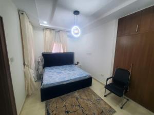 a bedroom with a bed and a chair in it at 3 Bedroom Apartment in Lekki in Lekki
