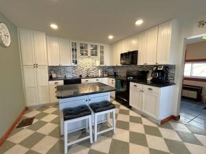 a kitchen with white cabinets and a checkered floor at Lady Mary Angeline in Saint Ignace