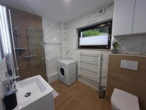 uma casa de banho com um lavatório, um WC e uma janela. em Apartment Break em Rob