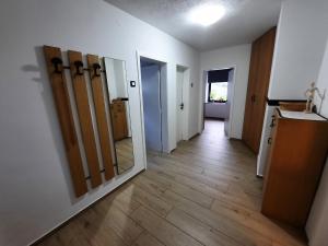 ein leeres Zimmer mit einem Flur mit Türen und Holzböden in der Unterkunft Apartment Break in Rob
