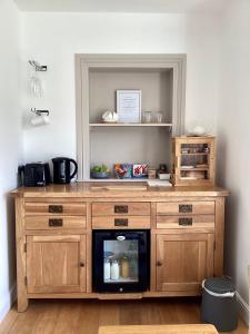 a wooden cabinet with a microwave in a room at The Garden rooms in Bedale