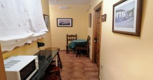 przedpokój z pokojem wyposażonym w kuchenkę mikrofalową i stół w obiekcie Villa y Corte - Castillo w mieście Ampudia