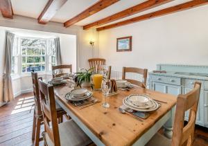 a dining room with a wooden table and chairs at Churchtown Cottage in Blisland