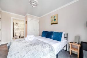 a bedroom with a large bed with blue pillows at Stylish Chic Retreat: 1-bed, Near Canary Wharf in London