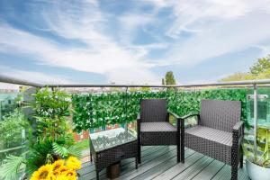 duas cadeiras numa varanda com plantas em Stylish Chic Retreat: 1-bed, Near Canary Wharf em Londres