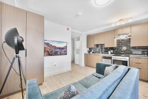 a living room with a blue couch and a kitchen at Skye Residences in Toronto