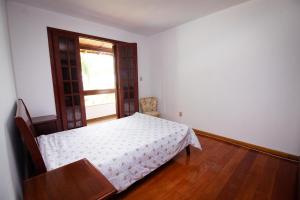 Schlafzimmer mit einem Bett, einem Tisch und einem Fenster in der Unterkunft Chacara totalmente equipada em Juiz de Fora MG in Juiz de Fora