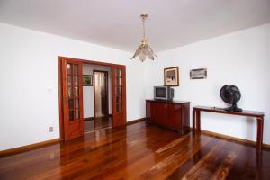 a living room with wooden floors and a ceiling at Chacara totalmente equipada em Juiz de Fora MG in Juiz de Fora