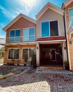 une maison avec un balcon au-dessus d'une allée en briques dans l'établissement Swiss Cottage Bhurban, à Bhurban