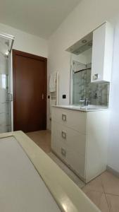a white kitchen with a sink and a mirror at Aeroporto e Fiera 30 in Seriate