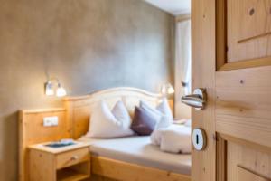 1 dormitorio con 1 cama con almohadas blancas en Ronsolhof Ortler en Siusi