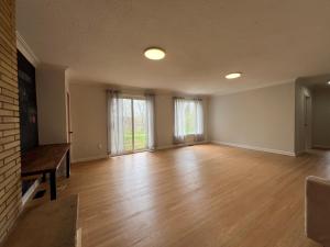 uma sala de estar vazia com pisos de madeira e janelas em ViHome-Quite House Shared Room near Don Mills Dvp & 401 em Toronto