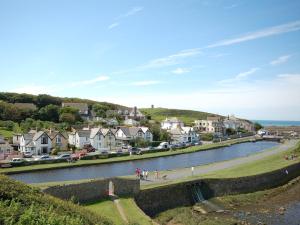 a river in a town with houses and cars at 4 Bed in Bude CORYS in Morwenstow