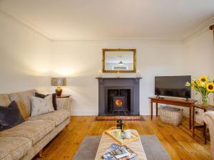 a living room with a couch and a fireplace at 4 Bed in Corwen 88868 in Corwen