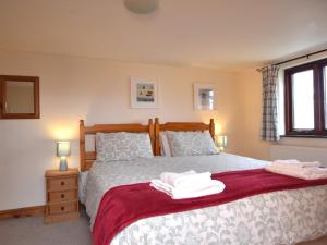 a bedroom with a bed with two towels on it at 3 Bed in Bude CORYM in Morwenstow