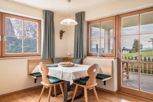 comedor con mesa, sillas y ventanas en Ronsolhof Ortler en Siusi