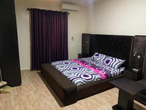 1 dormitorio con 1 cama grande y cabecero negro en Light house en Lagos