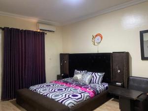 um quarto com uma cama com uma cabeceira preta em Light house em Lagos