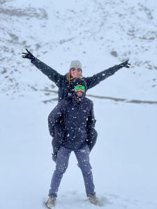 a woman standing on top of a man in the snow at Hotel Rosim Cotopaxi in Latacunga