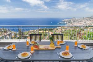 a table with plates of food on a balcony at Bay Bliss by Atlantic Holiday in Funchal
