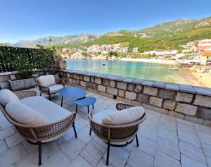 d'une terrasse avec des chaises et des tables et une vue sur la plage. dans l'établissement Kazanegra Exclusive Apartments, à Sveti Stefan