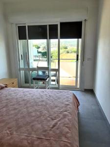 a bedroom with a bed and a window with a chair at APPARTAMENTO con TERRAZZA SUL MARE in Santa Marinella