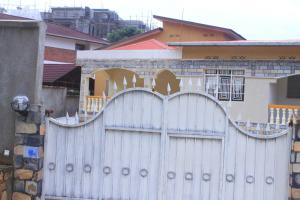 una cerca blanca con una puerta delante de una casa en Kiriri SYMPA Home, en Buyumbura
