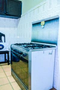 y cocina con fogones y horno. en Kiriri SYMPA Home en Buyumbura