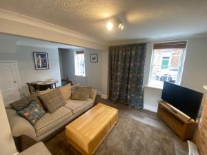 uma sala de estar com um sofá e uma televisão em Characterful 3 Bed cottage in Barrow upon Humber em Barrow upon Humber