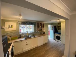 uma grande cozinha com armários brancos e um lavatório em Characterful 3 Bed cottage in Barrow upon Humber em Barrow upon Humber