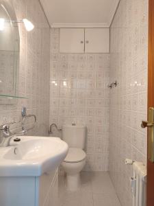 y baño con aseo blanco y lavamanos. en JL Cristobal Lozano en Albacete