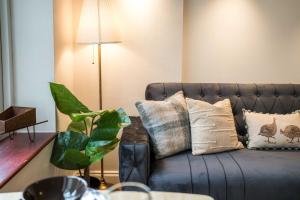 sala de estar con sofá azul y almohadas en Elephant&Castle Apartments By Sleepy, en Londres