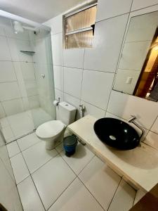 a bathroom with a black sink and a toilet at Pousada Meu Xodó in Jericoacoara