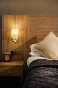 The Seven Chester في تشيستر: غرفة في الفندق بها سرير ومصباح على الحائط