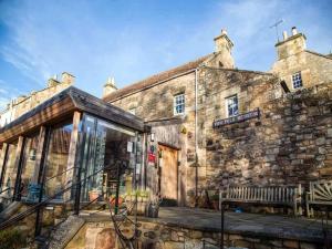 Ceresにある2 Bed in St Andrews 78228の前方にベンチのある古い石造りの建物
