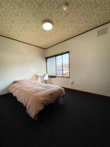 a bedroom with a bed and a window in it at アラン別邸自然溢れる呼人の一軒家 in Yobito