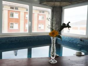 a vase with a flower on a table next to a window at B & B Da Lella in Trieste