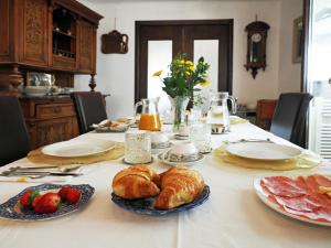 トリエステにあるB & B Da Lellaのクロワッサンのパンとフルーツを盛り付けたテーブル