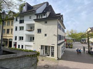 un edificio blanco con techo negro en una calle en Ferienwohnung Seeromantik in 2 Minuten am See, en Radolfzell am Bodensee
