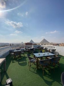 a row of tables and chairs on a balcony at Explore Stars Pyramids View in Cairo