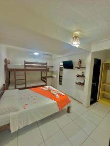 een slaapkamer met een bed met een oranje deken bij Pousada Meu Xodó in Jericoacoara