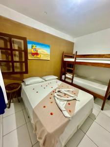 a bedroom with two beds and a bunk bed at Pousada Meu Xodó in Jericoacoara