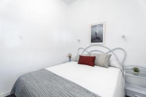 - une chambre blanche avec un lit et un oreiller rouge dans l'établissement casacamer, à Sagonte